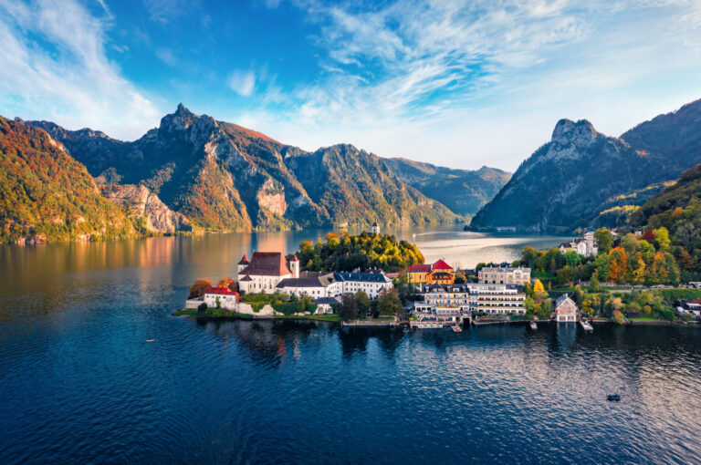 View from flying drone. Picturesque morning view of Maria Kronung church. Aerial autumn scene of Traunsee lake. Stunnig landscape of Austrian Alps with Traunstein peak on background, Austria, Europe.